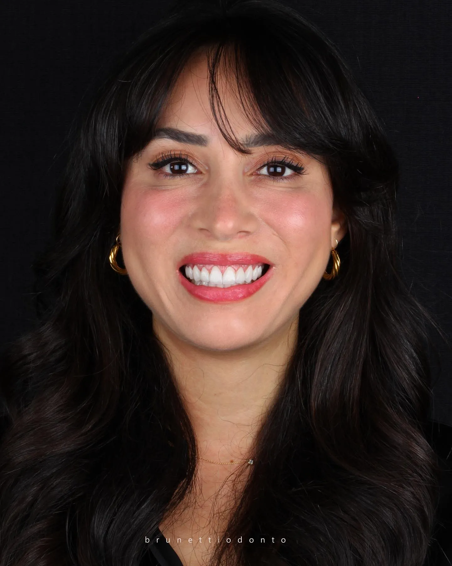 Retrato de mulher com sorriso natural em fundo escuro